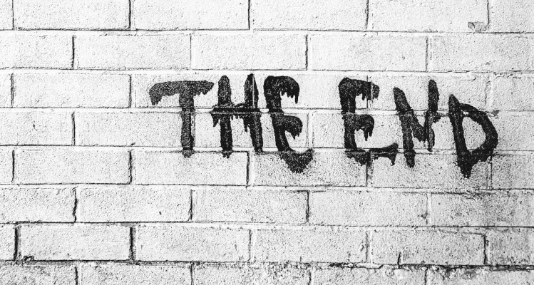 Image is of the words the end in black spray paint on a white wall